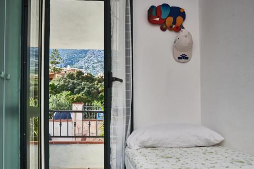a bedroom with a door open to a balcony at Villetta Vista Mare in Cala Gonone