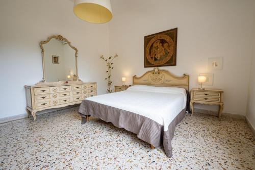 una camera con letto, cassettiera e specchio di Terrazza vista mare-Cefalù a Cefalù