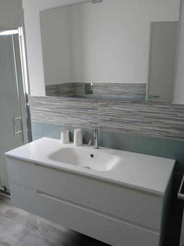 a bathroom with a white sink and a mirror at Palms Villa in Scopello