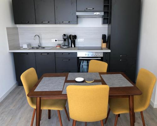 a kitchen with a wooden table and yellow chairs at Sancerre Sunflower - Tournesol de Sancerre in Sancerre