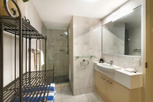 a bathroom with a sink and a shower and a mirror at 8 30EDGAR Noosa Heads Come Stay awhile in Noosa Heads