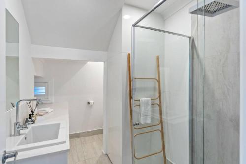 y baño con ducha y lavamanos. en PACIFIC Stunning Coastal Home The Perfect Family Getaway, en Sunshine Beach