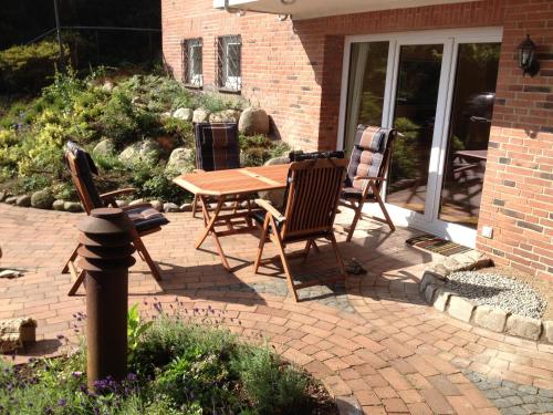 a patio with a wooden table and chairs at Fewo Eckernförde mit Meerblick in Eckernförde