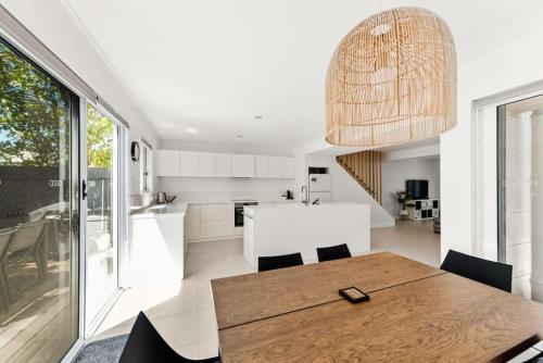 a kitchen and dining room with a wooden table and chairs at BARBADOS Ultimate Laid-back Holiday - Flat Stroll to River in Noosaville