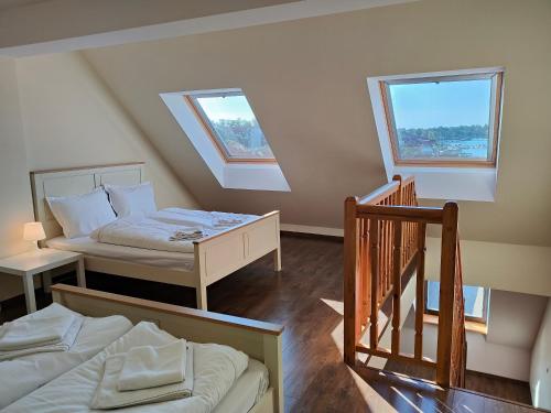 a attic room with two beds and a staircase at Apartament Alex in Mikołajki