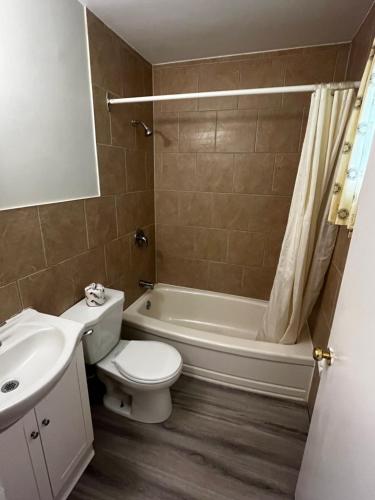 a bathroom with a toilet and a tub and a sink at Elect Inn 5 in Cornwall