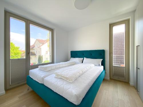 a bed in a room with two large windows at Strandläufer 2 in Zingst