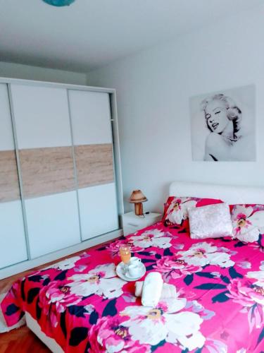 a bedroom with a large bed with a floral bedspread at Holiday home Buljat in Kaštela