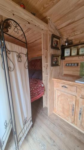 a small room with a bed in a tiny house at La roulotte au coeur du maquis in Carbuccia