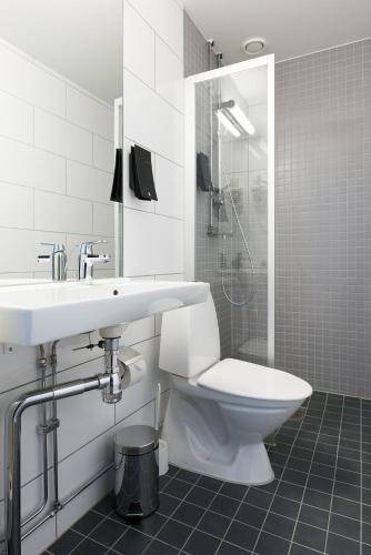 a bathroom with a toilet and a sink and a shower at Home Hotel Plaza in Karlstad