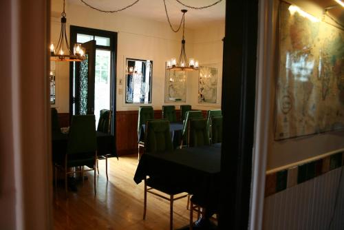 a dining room with a table and green chairs at Auberge Presbytere Mont Lac-Vert in Hébertville