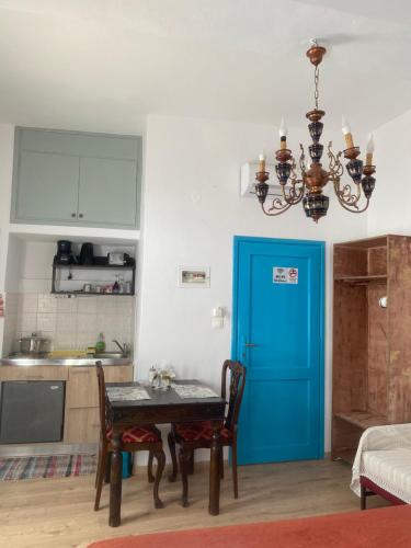 a kitchen with a table and a blue door at DIONI in Chania Town