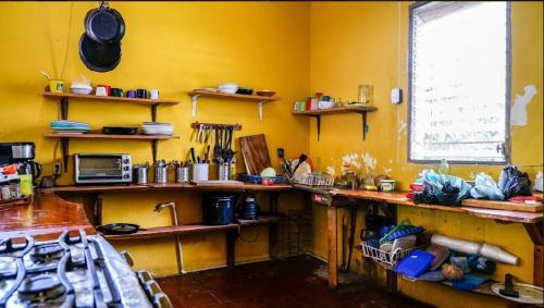 a kitchen with yellow walls and a counter top at Casa de Colores in El Zonte