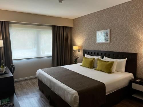 a hotel room with a large bed with yellow pillows at Days Inn Zarate in Zárate