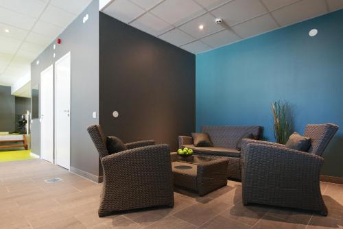 a waiting room with chairs and a table at Home Hotel Plaza in Karlstad