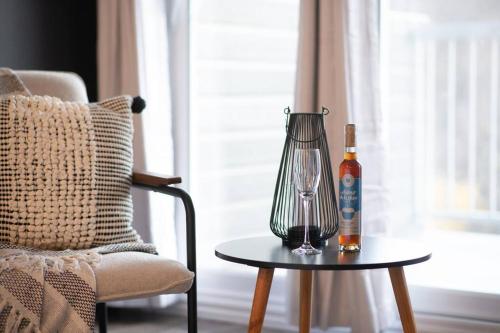 un jarrón y una botella en una mesa junto a una silla en Studio LIV204 by Gestion ELITE, en Mont-Tremblant