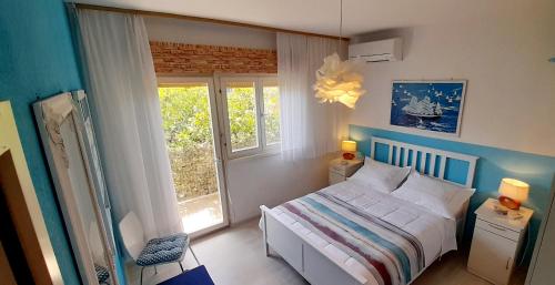 a bedroom with a white bed and a window at Apartment sea view Marija Franić in Slatine
