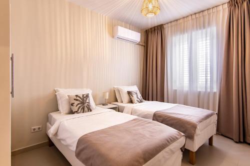 ein Hotelzimmer mit zwei Betten und einem Fenster in der Unterkunft Otrobanda Apartment in Willemstad
