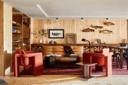 a living room with red chairs and a couch at Bluebird Sunapee in Mount Sunapee