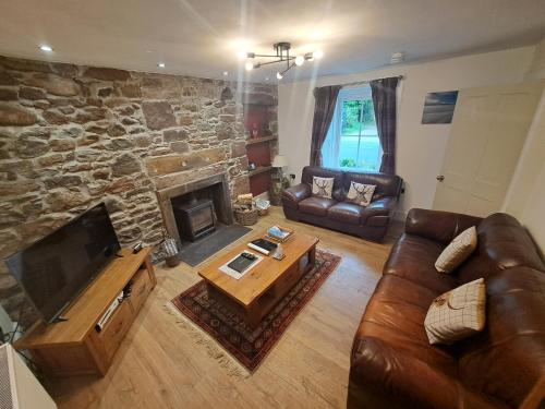 a living room with a couch and a fireplace at Clematis Cottage, Fortrose in Fortrose
