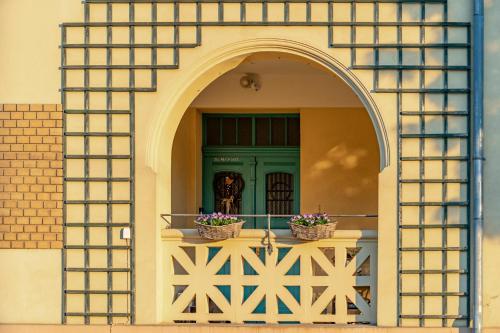 an arched window with two baskets of flowers on a balcony at Vila Heide in Česká Kamenice