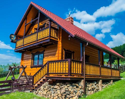 a log cabin with a red roof at Chatka Pod Laskiem - Domki w górach in Soblówka