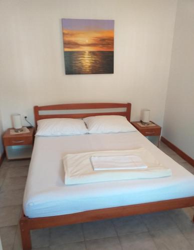 a bed in a room with two nightstandiatesiatesiatesiatesiatesiatesiates at Apartments Jakov in Starigrad