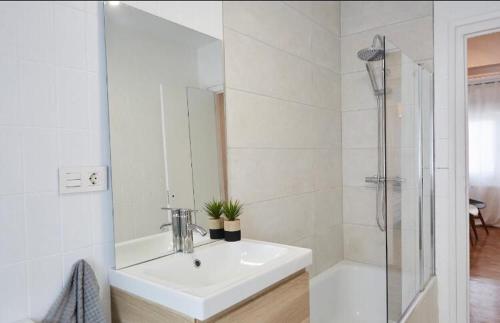 a white bathroom with a sink and a shower at Apartamento Pamplona in Pamplona