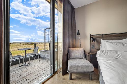 a bedroom with a bed and a balcony with a table at Lily Country Club in Klofta