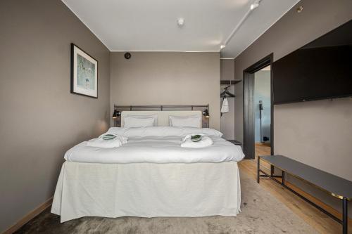 a bedroom with a large white bed with towels on it at Lily Country Club in Klofta