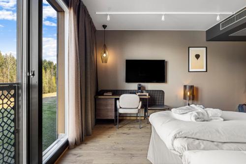 a hotel room with two beds and a desk and a television at Lily Country Club in Klofta