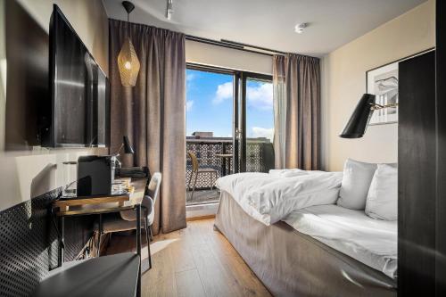 a hotel room with a bed and a desk and a window at Lily Country Club in Klofta