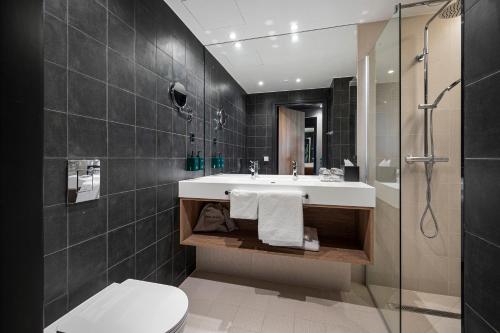 a bathroom with a sink and a toilet and a shower at Lily Country Club in Klofta