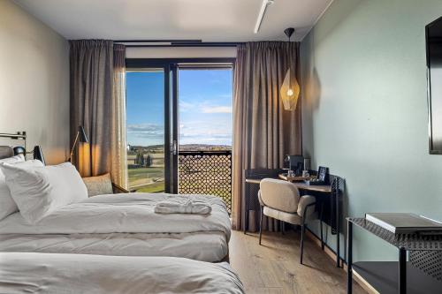 a hotel room with two beds and a desk and a window at Lily Country Club in Klofta