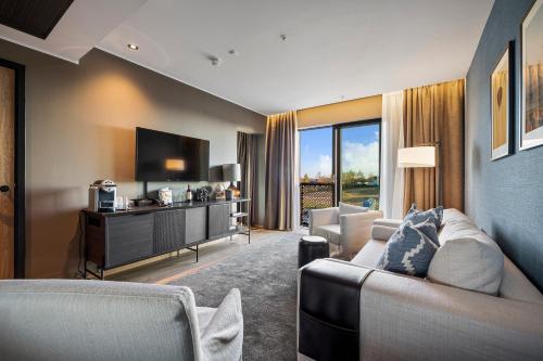 a living room with a couch and a tv at Lily Country Club in Klofta