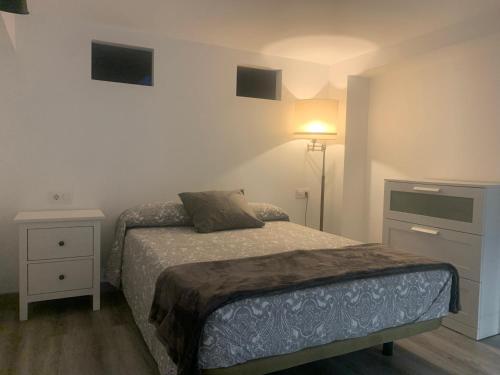 Dormitorio pequeño con cama y lámpara en HOLIDAY ALYMA, en Sanlúcar de Barrameda
