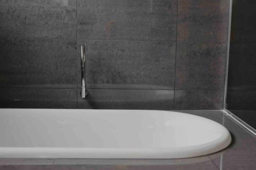 a white toilet in a bathroom with a faucet at Martyrs Lookout - Luxury Accommodation in Peterborough