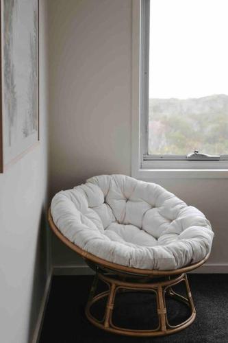 a white tufted stool sitting in front of a window at Martyrs Lookout - Luxury Accommodation in Peterborough