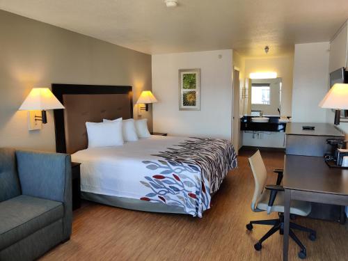 a hotel room with a large bed and a desk at Red Roof Inn Houston - Jersey Village in Houston
