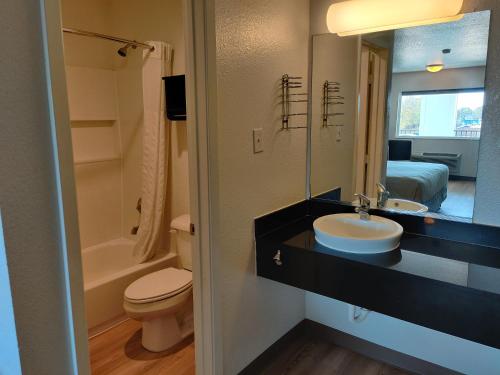 a bathroom with a sink and a toilet and a mirror at Red Roof Inn Houston - Jersey Village in Houston