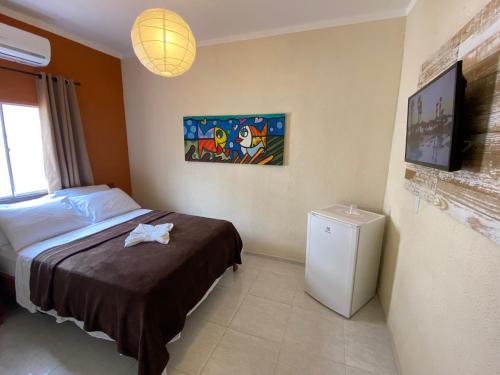 um quarto com uma cama e uma televisão em Refúgio Pousada Fortaleza em Fortaleza