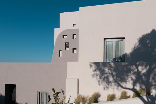 a white building with trees in front of it at Elements Cozy Suites Pyrgos in Pirgos