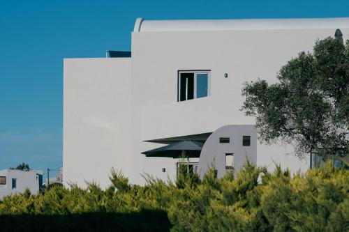a white building with a window and an umbrella at Elements Cozy Suites Pyrgos in Pirgos