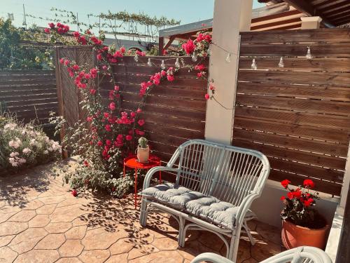 a patio with a bench and a fence with flowers at Villa Doreta in Roda