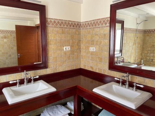 a bathroom with two sinks and two mirrors at Villa Neila, Fuerteventura in Tarajalejo