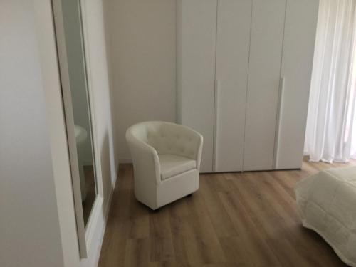 a white chair in a room with a mirror at Ca’ Uccelli-Stupendo Appartamento 5 min da Venezia in Marghera