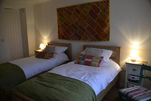 dos camas sentadas una al lado de la otra en una habitación en Fig Tree House, en Penryn