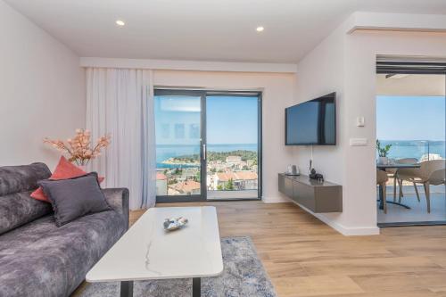 ein Wohnzimmer mit einem Sofa und einem TV in der Unterkunft Luxury Adria SEA & CITY View apartment in Makarska