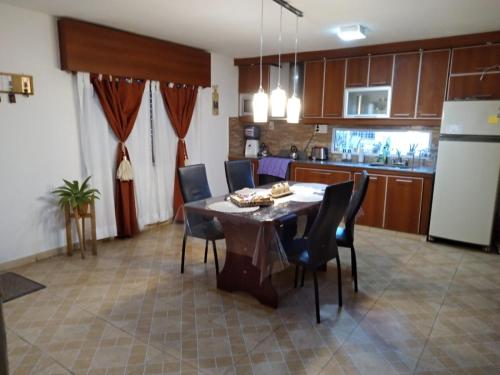 cocina y comedor con mesa y sillas en Casa con piscina de uso exclusivo en Gualeguaychú
