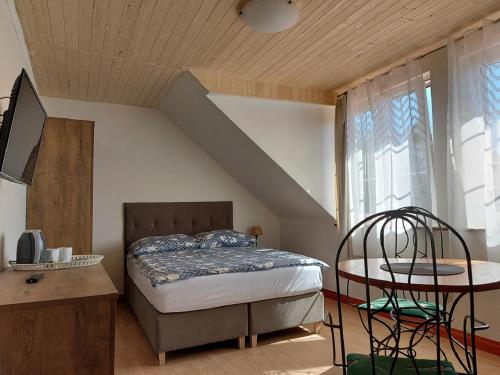 een slaapkamer met een bed, een tafel en een raam bij Widok Na Port in Łeba